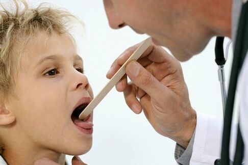 Doctor examining the throat of a child with psoriasis